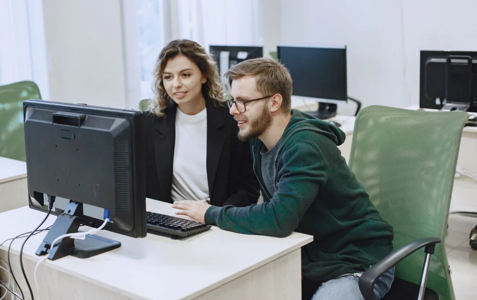two it testers looking at the monitor in the office